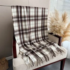Dettaglio sciarpa scialle scozzese retrò simil cashmere con elegante motivo marrone e frange.
