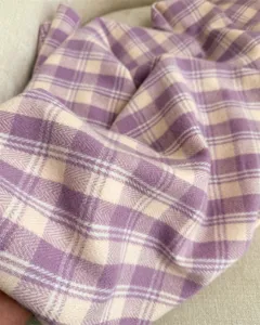 Purple beige plaid cashmere-like scarf detail showing soft warm winter fabric texture.