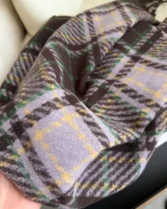 Close-up detail of the cozy plaid scarf showing soft fabric texture and colorful pattern.