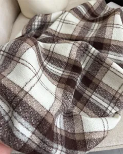 Dettaglio sciarpa a quadri marrone classica. Morbido scialle invernale, caldo scaldacollo unisex.