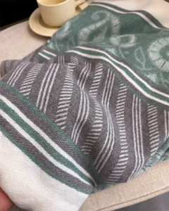 Close-up detail of cozy woven scarf texture, showing soft striped pattern and warm autumn style.