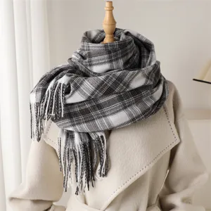 Detailed view of the classic black and white plaid cashmere-feel scarf with fringe edges.