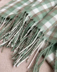 Close-up detail shot of retro green plaid imitation cashmere scarf with elegant fringe