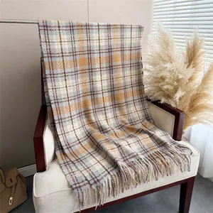 Detailed view of the cozy plaid loop yarn cashmere-feel scarf draped on a chair with fringe.