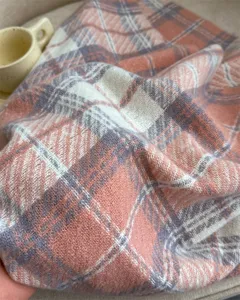 Close up of soft pink plaid cashmere feel winter scarf fabric detail texture cozy mood.