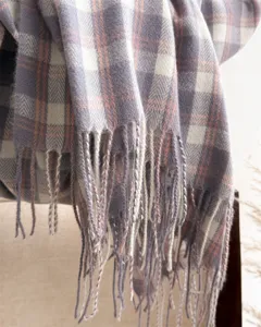 Close up shot of vintage plaid scarf texture and delicate fringe details, soft fabric.