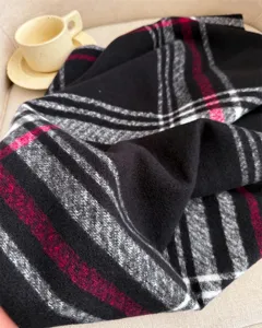 Detailed close-up of winter plaid cashmere-feel scarf, soft texture and cozy warmth design.