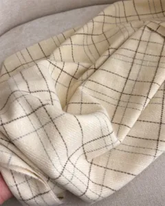 Vue détaillée d'une écharpe imitation cachemire à carreaux beige, douce et chaude.