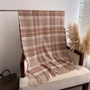 Close-up detail view of a cozy brown plaid cashmere-feel fringed shawl and scarf for autumn