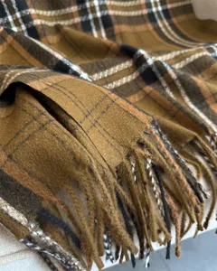 Primo piano dettagliato di sciarpa a quadri classica con consistenza morbida e frange.