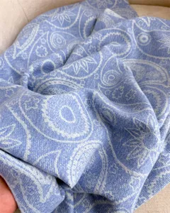 Close-up detail shot of the soft blue paisley scarf texture, showcasing fine autumn winter knit.