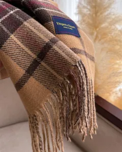 Detailed close-up view of classic plaid cashmere-feel winter scarf with fringe trim.