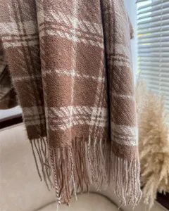 Detailed close-up of cozy brown plaid loop yarn imitation cashmere scarf with soft tassels.