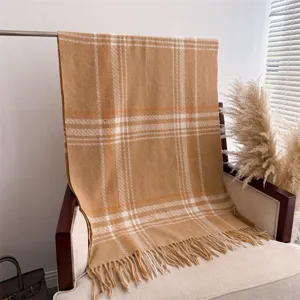 Detailed view of a soft cashmere-feel tassel plaid shawl scarf in classic camel color.