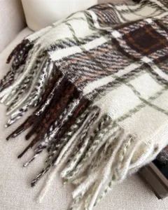 Close-up detail of cozy plaid tassel scarf winter warm cashmere-feel wrap soft fringe design.