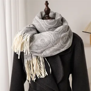 Close-up detail of grey paisley pattern winter scarf with fringe, soft cashmere-feel fabric.