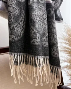 Close-up detail of winter warm imitation cashmere tassel scarf, elegant dark pattern shawl.