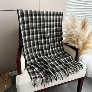 Classic black and white plaid pattern cashmere feel shawl scarf draped elegantly on chair.