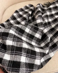 Close-up of black and white plaid cashmere-like scarf detail, cozy winter accessory.