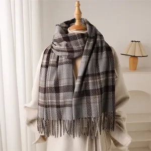 Cozy plaid scarf detail close-up showing soft cashmere-like texture and elegant fringe.