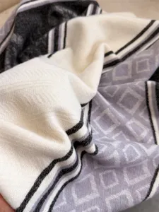 Close-up detail of imitation cashmere winter scarf with geometric rhombus and stripe patterns.