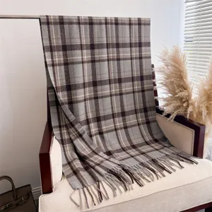 Detail shot of a grey plaid faux cashmere scarf with fringe, elegant autumn winter accessory