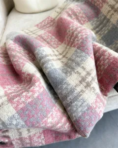 Close-up detail of cozy plaid winter scarf soft loop yarn texture aesthetic showcase.