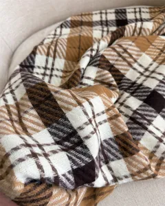 Detailed view of soft plaid cashmere-feel scarf, cozy winter warm fashion accessory.