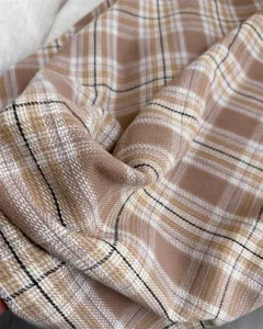 Close-up detail view showing the soft cashmere-feel beige plaid winter scarf fabric.