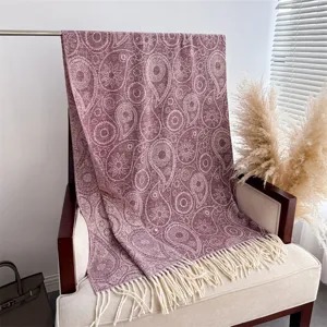 Detailed view of autumn winter paisley tassel scarf soft cashmere feel shawl draped on chair.