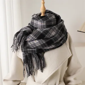 Detailed view of the cozy black and grey plaid cashmere-feel scarf with delicate fringe edges.