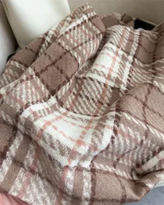 Detailed view of brown plaid faux cashmere scarf, soft loop yarn texture, warm winter accessory.