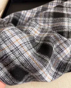Close-up detail of classic black and white plaid cashmere-feel winter scarf accessory.
