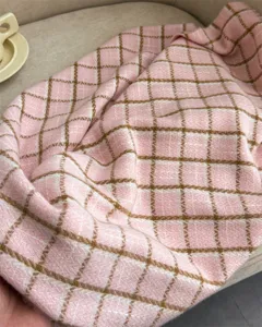 Nahaufnahme eines weichen, rosa-braunen Karo-Schals in Kaschmir-Optik für kalte Wintertage.