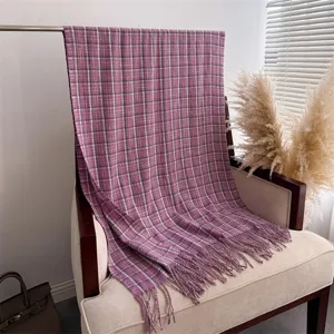 Nahaufnahme eines violetten Karoschal-Details mit weichem Kaschmir-Gefühl und eleganten Fransen.