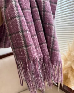 Nahaufnahme von lila kariertem Kaschmir-Gefühl Winterschal mit weichen Fransen, Detail.