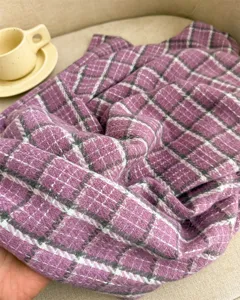 Nahaufnahme des weichen lila Karo-Winterschals mit gemütlicher Textur und feiner Webung.