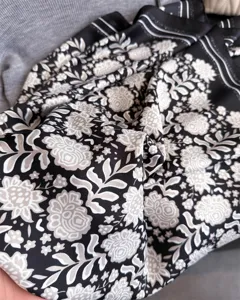 Gros plan sur la texture du tissu du carré de foulard en satin sergé à fleurs vintage.