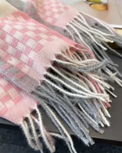 Close-up detail of soft faux cashmere plaid scarf with fringe, showing texture and quality.