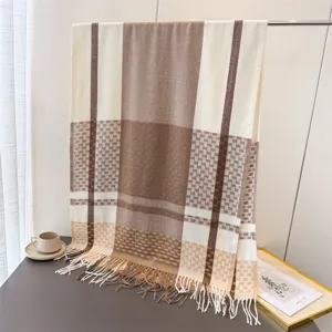 Detailed shot of cozy brown and cream plaid fringed scarf displayed on a neat tabletop.