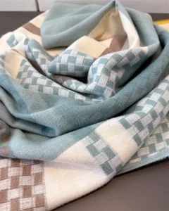 Close-up detail of soft cashmere-feel plaid winter scarf showcasing cozy knit texture.