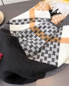 Detailed close-up of a classic plaid faux cashmere scarf with fringe, soft texture for winter.