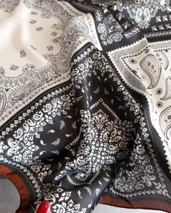 Foulard carre en soie a imprime paisley noir et blanc classique, accessoire elegant.