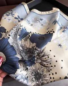 Close-up detail of luxury floral print silk square scarf, elegant blue and beige aesthetic.