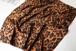 Detailed close-up shot showing the luxurious satin fabric texture and classic leopard print design.