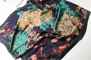 Close-up detail of luxury navy blue floral printed silk scarf with elegant peony pattern.