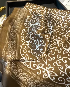 Detailed view of the elegant brown silk square scarf featuring a classic baroque paisley print.