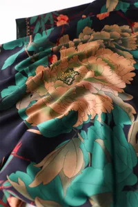 Detailed view of floral print silk feel scarf showing elegant peony pattern and smooth fabric texture.
