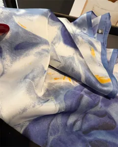 Detailed view of blue floral imitation silk square scarf, elegant neck wrap and sun shawl.