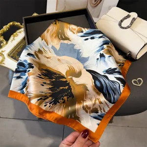 Detailed close-up of a stylish square silk scarf with abstract floral print and vibrant orange border.